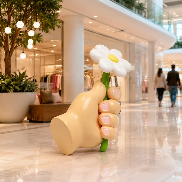Hånd som holder blomsterskulptur